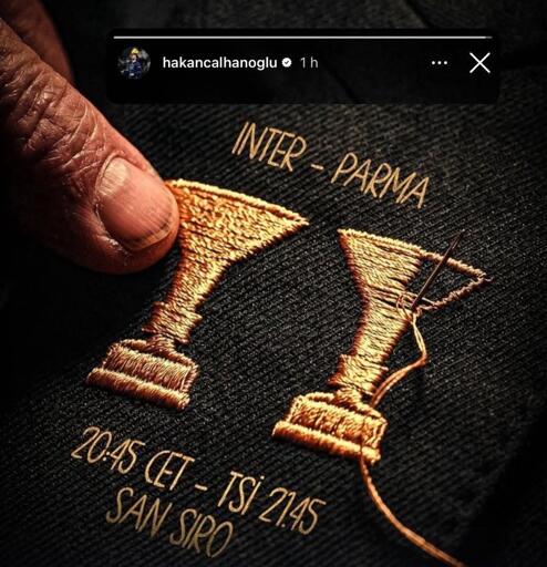 Primo piano di una mano che tiene un disegno ricamato con due trofei d'oro con "INTER - PARMA" sopra di loro. Di seguito, il testo indica un orario di partita: "20:45 CET - TSI 21:45 SAN SIRO".
