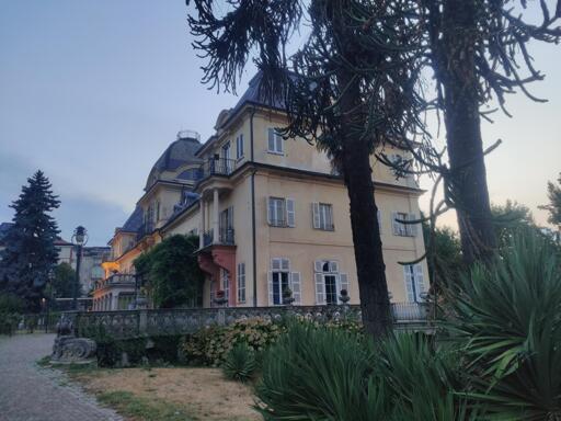 Villa in stile liberty e scorcio del suo giardino.
La villa è oggi sede del municipio.
Le pareti sono di una particolare tonalità di giallo, con alcuni elementi rossi.
Nel giardino si vedono palme e altri fiori.